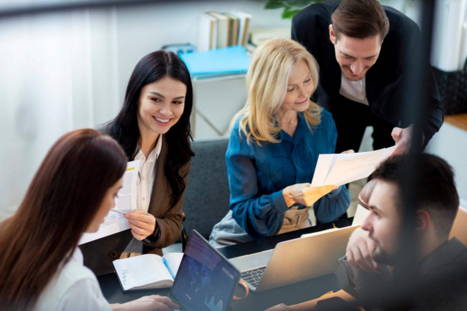Professionelles Team bespricht Wirtschaftsanalytik in modernem Büro